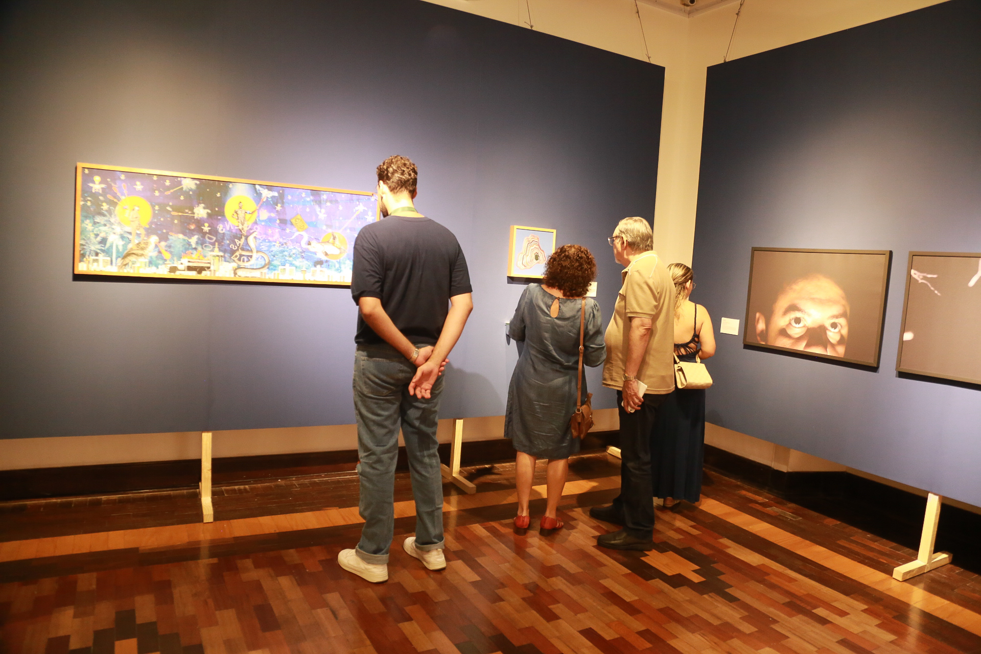 grupo de pessoas observando as obras do Salão de Abril